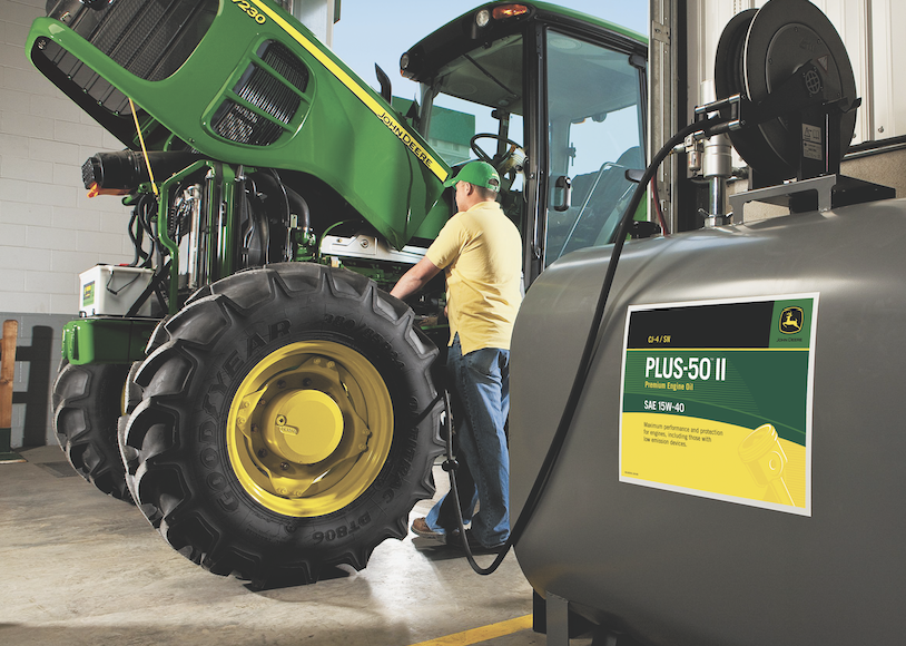 Farmer Filling Tractor with John Deere Plus-50 II Oil